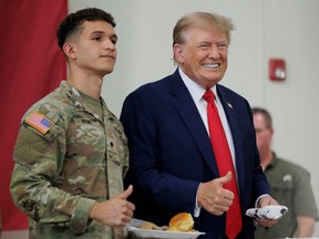 Former U.S. president Donald Trump poses for a photo with a service member at the South Texas International airport on Nov. 19, 2023 in Edinburg, Texas.
