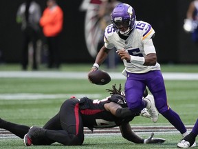 Minnesota Vikings quarterback Joshua Dobbs (15) runs for a first down past an Atlanta Falcons' defender during the second half of an NFL football game, Sunday, Nov. 5, 2023, in Atlanta.