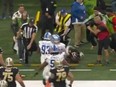 New Orleans Saints' Alvin Kamara tumbles into a sideline official.