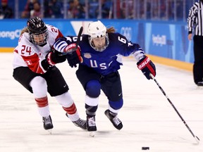Kali Flanagan of the United States controls the puck against Natalie Spooner of Canada.