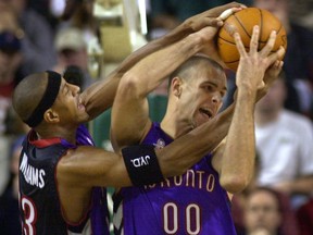 Toronto Raptors teammates Jerome Williams, left, and Eric Montross fight for a rebound in 2001.