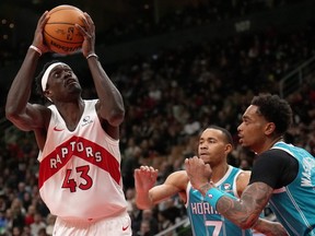 Toronto Raptors forward Pascal Siakam eyes the basket under pressure from Charlotte Hornets guard Bryce McGowens (7) and teammate P.J. Washington (25).