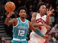 Charlotte Hornets forward Leaky Black (12) looks on as Toronto Raptors forward Scottie Barnes (4) passes the ball.