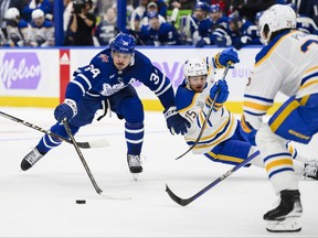 Toronto Maple Leafs centre Auston Matthews is defended by Buffalo Sabres Connor Clifton (75) and Owen Power.