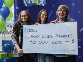 Jeannette Boisvert, left, Nancy Gauthier and Gilles Larouche are presented with a representation of a $50-million cheque at Loto-Québec's head office in Montreal on Thursday, Dec. 21, 2023.