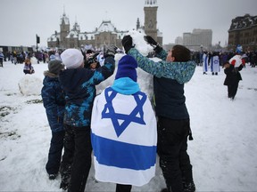 Children make a snowman as demonstrators gather in support of the Jewish community, on Parliament Hill in Ottawa on December 4, 2023