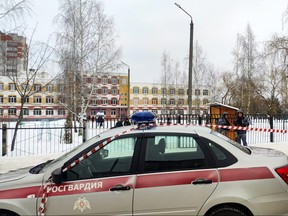 Law enforcement officers stand guard outside Gymnasium Number Five following a shooting, in Bryansk on December 7, 2023.
