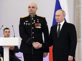 This pool photograph distributed by Russian state agency Sputnik shows Russia's President Vladimir Putin awarding Captain Mikhail Polushkin during a ceremony to present Gold Star medals to Heroes of Russia on the eve of the Heroes of the Fatherland Day at the St. George Hall of the Grand Kremlin Palace in Moscow on December 8, 2023.