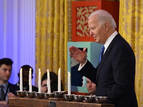 U,S, President Joe Biden waves as he walks by the Menorah during a Hanukkah reception in the East Room of the White House in Washington, DC, on December 11, 2023. (Photo by ANDREW CABALLERO-REYNOLDS/POOL/AFP via Getty Images)