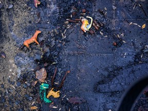 Kids toys lay amongst ashes.