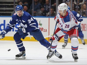 Maple Leafs' Auston Matthews (left) and New York Rangers' Chris Krieder battle for the puck at Scotiabank Arena on Dec. 19, 2023 in Toronto.
