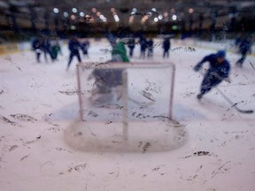 Rubber marks from pucks dot the glass at a hockey practice in Vancouver on Thursday, June 2, 2011.