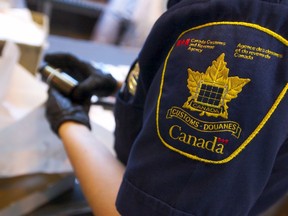 Canada Border Services Agency Officer Constance Karpeil examines a package.