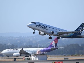 Alaska and Hawaiian Airlines planes takeoff from San Francisco International Airport (SFO) in San Francisco on June 21, 2023.