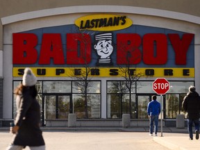 People walk past a Bad Boy furniture store.