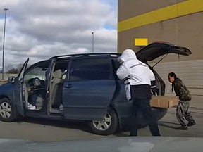 Crooks are seen stealing what looks like a large screen TV from a Best Buy store in Scarborough after an off-duty Toronto Police officer was stabbed when he tried to stop the thieves on Wednesday, Dec. 6, 2023.