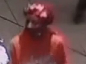 Fuzzy image of male assault suspect wearing red