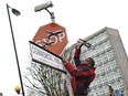 A person removes a piece of art work by Banksy