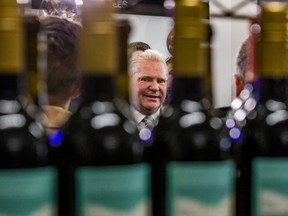 Doug Ford framed by wine bottles in the foreground