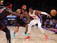 Pistons' Jaden Ivey, right, losses control of the ball next to Raptors' Gary Trent Jr. during first half NBA action at Little Caesars Arena in Detroit, Saturday, Dec. 30, 2023.