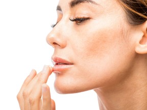 Woman moisturizing her lips.
