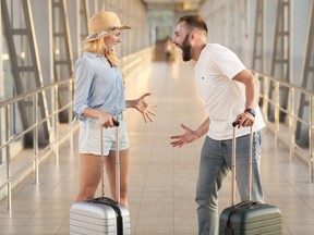 Couple arguing at airport terminal.