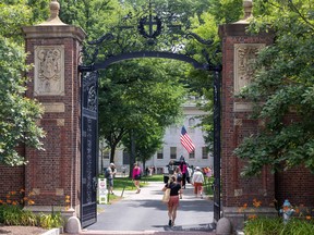 People walk through the gate on Harvard Yard at the Harvard University campus on June 29, 2023 in Cambridge, Mass.