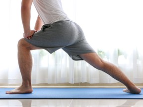 Man doing forward lunges on a blue yoga mat.