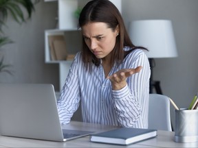 Annoyed young woman looking at computer screen.