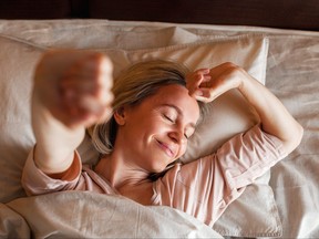 A woman stretches her arms after a good night's sleep in this file photo.
