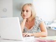 Curious woman looking at laptop.