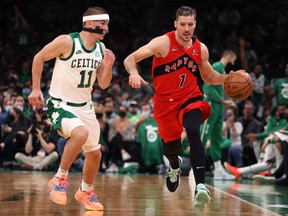Goran Dragic of the Toronto Raptors dribbles against Payton Pritchard of the Boston Celtics during the Celtics home opener at TD Garden on Oct. 22, 2021 in Boston.