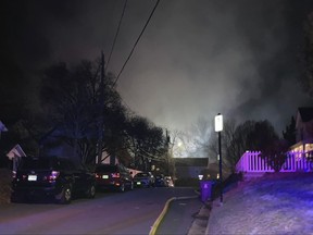 Smoke rises over a neighborhood where Virginia police say a house exploded as officers were trying to serve a search warrant.