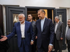 This handout picture provided by the Iranian foreign ministry on Dec. 20, 2023, shows Qatar-based Hamas leader Ismail Haniyeh (left) welcoming Iranian Foreign Minister Hossein Amir Abdollahian (centre), in Doha.