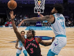 Hornets centre Nick Richards, right, blocks a shot by Raptors forward O.G. Anunoby during first half NBA action in Charlotte, N.C., Friday, Dec. 8, 2023.
