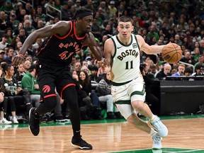 Celtics' Payton Pritchard, right, drives to the basket against the Raptors' Pascal Siakam, left, during second quarter NBA action at TD Garden in Boston, Friday, Dec. 29, 2023.