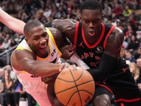 Raptors guard Dennis Schroder (right) battles for a loose ball with Utah Jazz guard Kris Dunn last night. Chris Young/THE CANADIAN PRESS