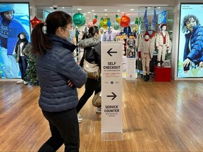 A sign pointing shoppers to self-checkout stations is shown at a store in New York on Wednesday, Dec. 6, 2023.