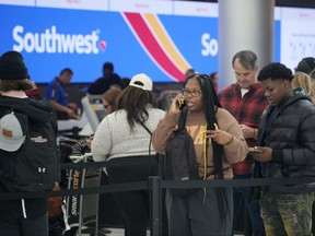 Travellers wait in line for service at the Southwest Airlines check-in counter at Denver International Airport on Dec. 27, 2022.