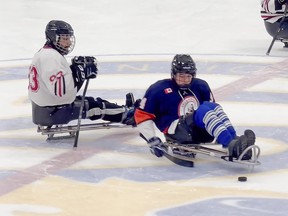 Keenan Sadler, 17, a true competitor who doesn't let his cerebral palsy or a recent broken left femur get him down, is seen here winning a faceoff in a sledge hockey game for the Markham Islanders.