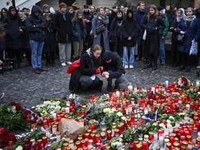 Mourners lay candle lights outside the headquarters of Charles University for victims of mass shooting in Prague, Czech Republic, Friday, Dec. 22, 2023. A lone gunman opened fire at a university on Thursday, killing more than a dozen people and injuring scores of people.