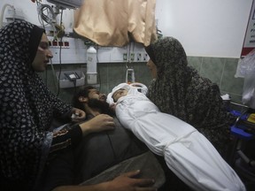 A Palestinian woman shows the body of her grandchild