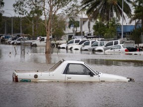 This picture shows cars amid floodwaters at Cairns Airport in Cairns on Dec. 18, 2023.