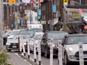An ambulance is stuck behind traffic that can't move over due to the bike lane on Yonge St. in a screengrab from video posted to Twitter.