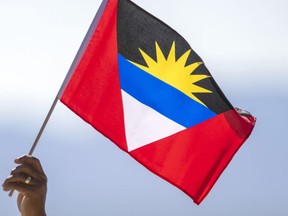 A person holds a flag of Antigua and Barbuda near Truth or Consequences, N.M., Thursday, Aug. 10, 2023. Two Canadians have died in Antigua, according to Global Affairs Canada. The department has not provided more information about the deaths that occurred in the Caribbean nation, citing privacy considerations.THE CANADIAN PRESS/AP, Andrés Leighton
