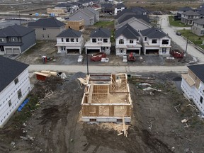 In this photo taken using a drone, homes under construction are seen in a new suburb, Friday, Oct. 15, 2021 in Ottawa.
