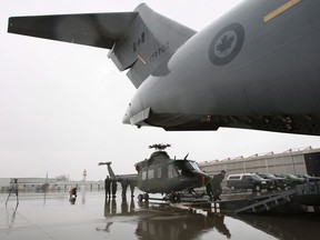 A CH-146 Griffon helicopter from Canadian Forces Base Bagotville, is being loaded onto a C-17 Globemaster airplane, at Canadian Forces Base Trenton in Trenton, Ont., on Sunday Nov. 17, 2013.