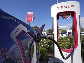 Tesla electric vehicles are seen at Tesla chargers