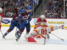 Colorado Avalanche right wing Mikko Rantanen, second from left, watches his shot go into for a goal as, from left, Calgary Flames center Nazem Kadri, defenseman Dennis Gilbert and goaltender Dan Vladar defend in the third period of an NHL hockey game Monday, Dec. 11, 2023, in Denver.