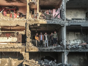 Palestinians check a half destroyed building following Israeli bombardment on Rafah, in the southern Gaza Strip, on Dec. 15, 2023, amid continuing battles between Israel and the Palestinian militant group Hamas.